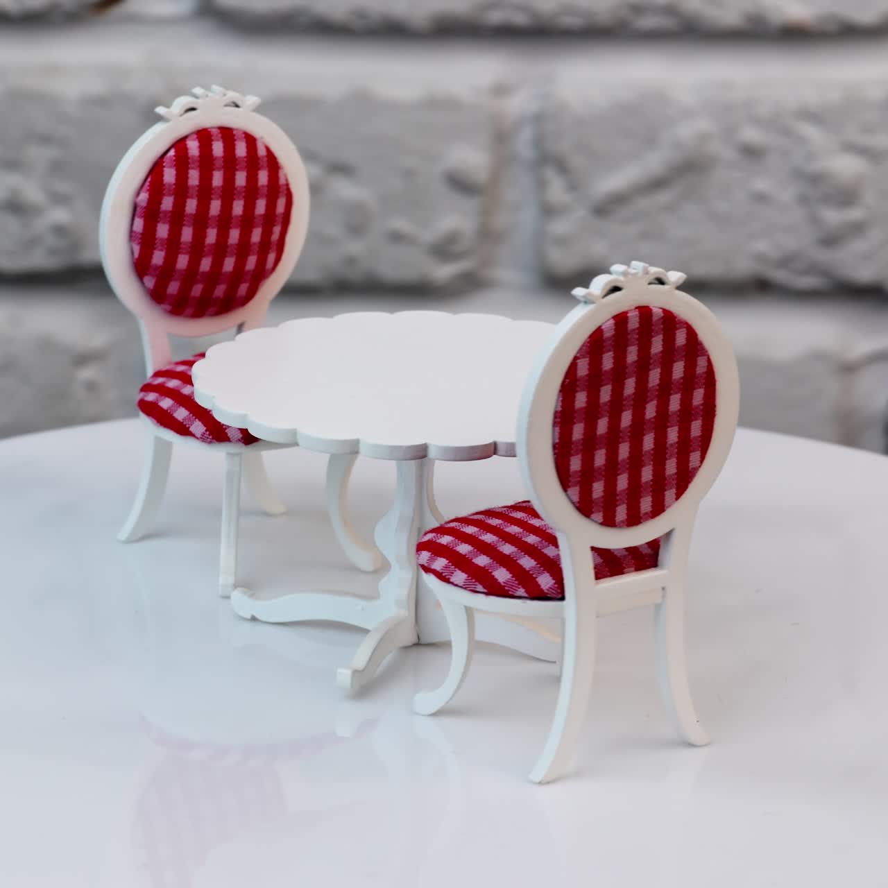 Adorable little white round table with two chairs on sides. Beautiful toy furniture at the rotating table