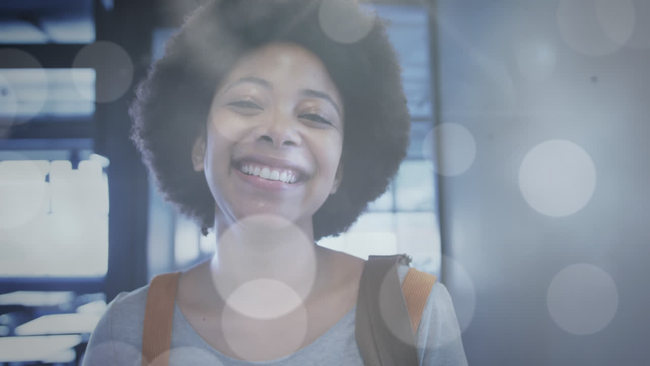 Animation of light spots over smiling african american businesswoman