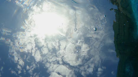 footage split between the wavy surface of the water of a swimming pool