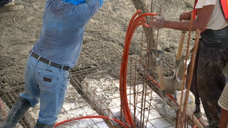 movimiento lento de un trabajador de la construcción latino mexicano usando una bomba de boom para aplicar la mezcla de hormigón en una cuadrícula con estiroespuma para construir el piso de losas de una casa nueva en méxico