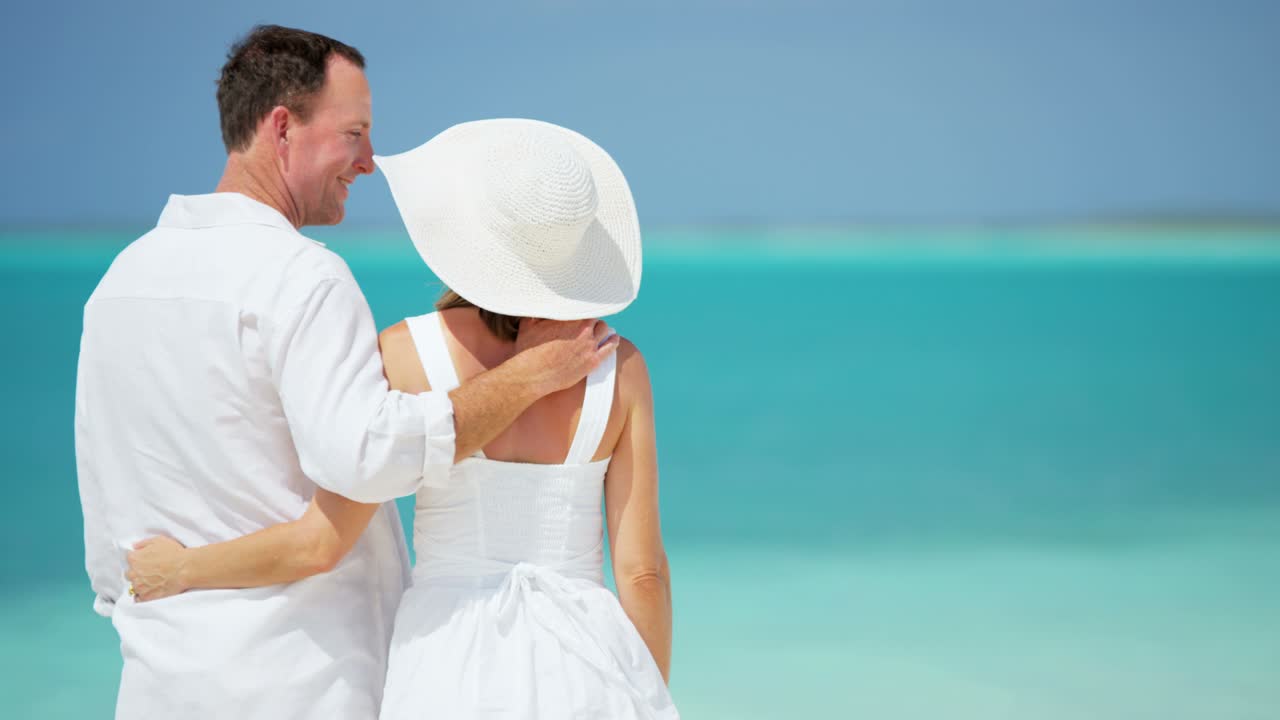 una atractiva pareja caucásica disfrutando de sus vacaciones en la playa.