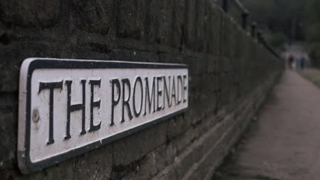 promenade street sign on a wall medium panning shot