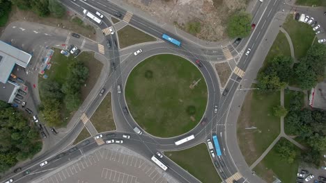 Aerial view car traffic at a roundabout in the big city. Top-down drone flight in spiral