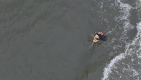 hydro foiler surfing wave behind watercraft filmed with drone from 90 degree