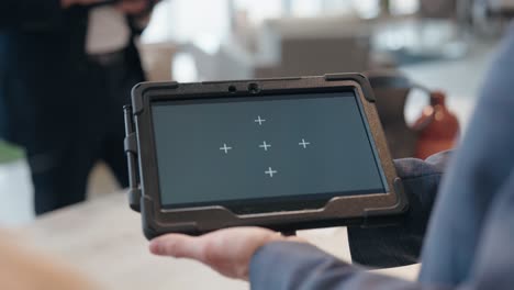 camera glides forward between people as suited presenter shows tracked tablet