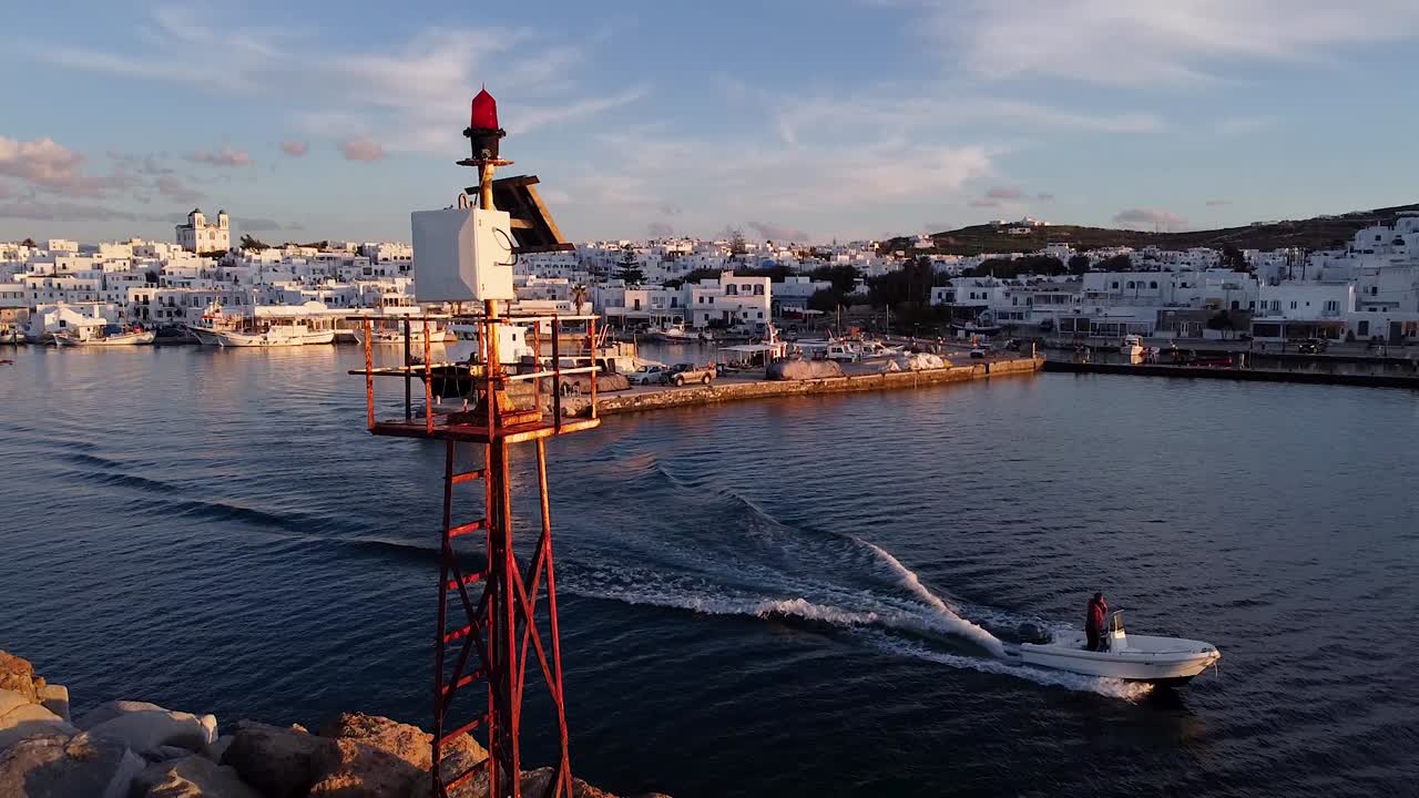 Small boat passes behind lighthouse
