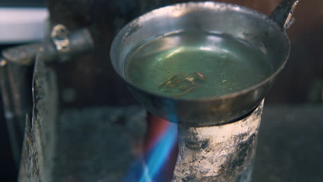 processing of gold snap in boiling green liquid close view