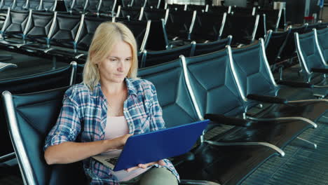 a woman uses a laptop in an airport lounge leisure pending flight