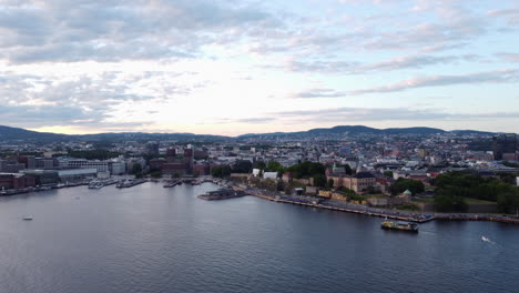 aerial flying backwards from port, oslo city in background, norway