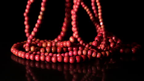 red prayer beads falling on black background