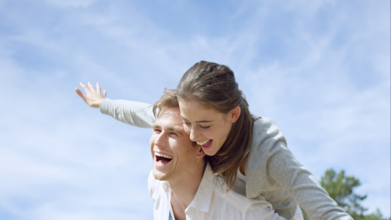 행복한 커플이 야외를 즐기고 미소 짓고 팔을 펴고 빨간 에픽 드래곤에 슬로우 모션 촬영을 하고 있습니다.