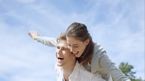 pareja feliz disfrutando al aire libre sonriendo brazos extendidos girando en cámara lenta en el dragón épico rojo