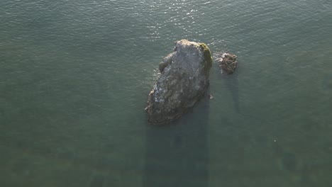 rugged stones and rocks emerge from the shallow and tranquil waters of the oregon coast, usa