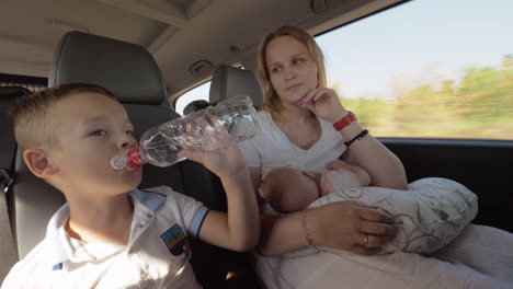 madre con dos hijos haciendo un viaje en coche