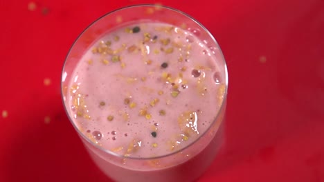 toma en cámara lenta de pequeños granos de cereales vertidos sobre yogur de frutas