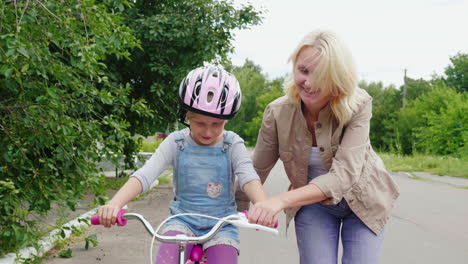 Mamá-Le-Enseña-A-Su-Hija-A-Andar-En-Bicicleta