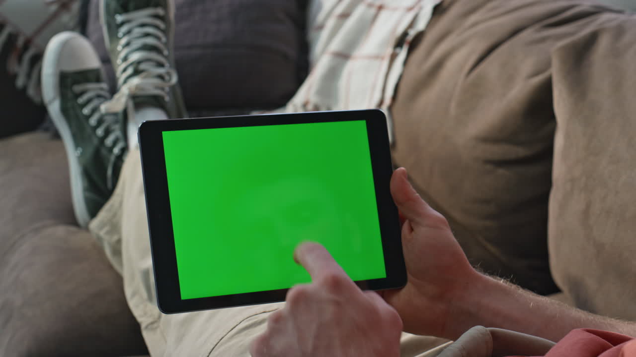 Man shopping online mockup tablet at home sofa closeup. Unknown guy scrolling