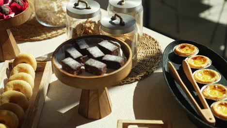 enjoy a pastry table at a hotel brunch with glamorous cakes and croissants beautifully lit by sun