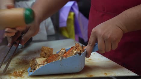 Puesto-De-Comida-Preparando-Pedidos-Para-Llevar,-Condimentando-Con-Deliciosa-Pimienta-Blanca,-Cinco-Especias,-Ajo-Y-Chile-En-Polvo-Sobre-Un-Sabroso-Pollo-Frito-Recubierto-De-Miel-De-Soja-En-El-Famoso-Mercado-Nocturno-De-La-Calle-En-Taiwán,-Asia