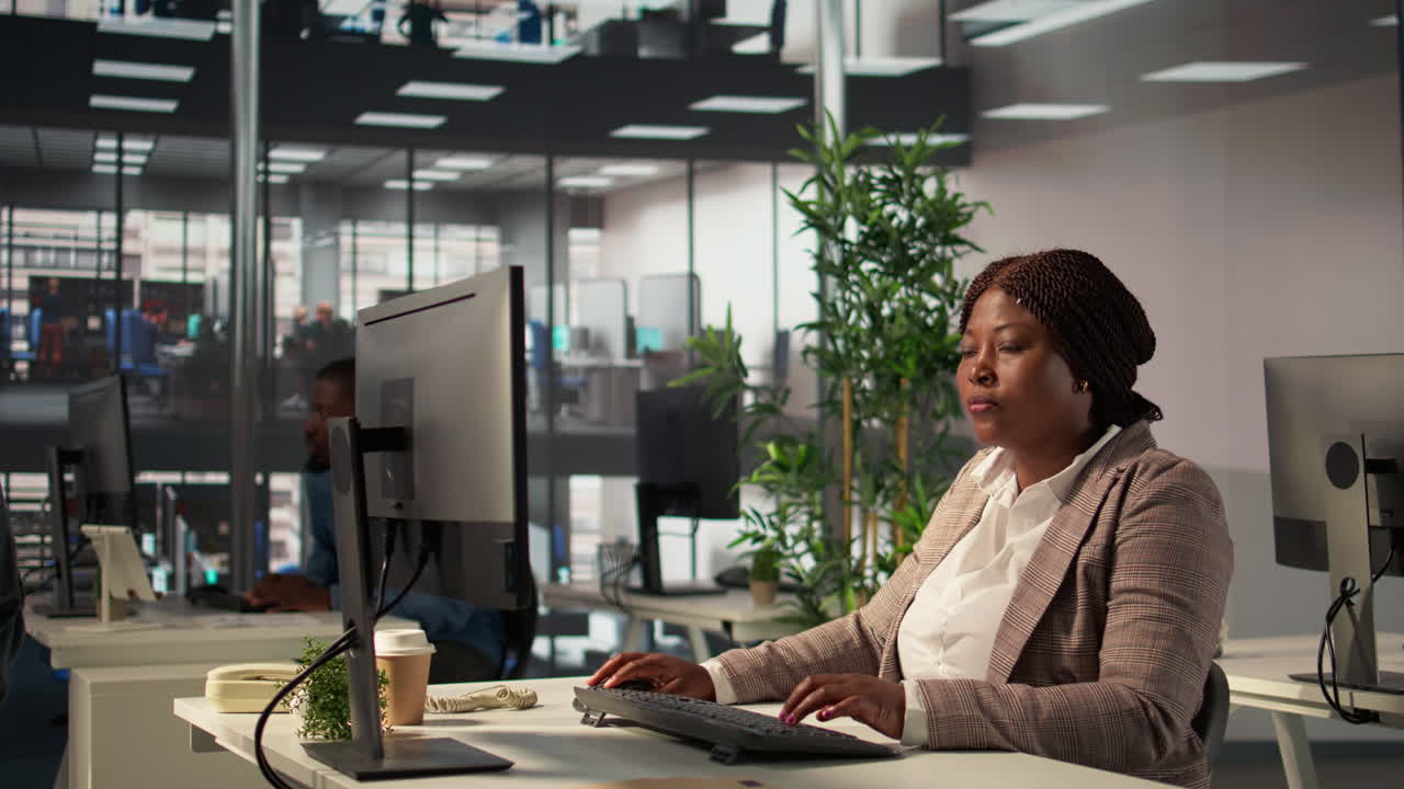 mujer trabajando en una computadora en una oficina moderna