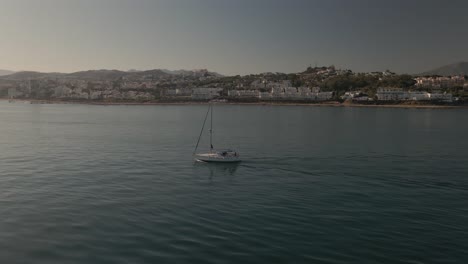 Órbita-Aérea-De-Veleros-A-Lo-Largo-De-La-Costa-Española-Mientras-Una-Rápida-Moto-De-Agua-Viaja-A-Través-De-La-Escena