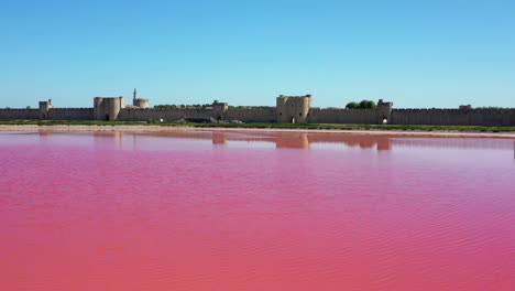 The-historical-town-of-Aigues-Mortes-in-the-Camargue,-France-during-a-sunny-summer-day-which-is-located-next-to-a-pink-salt-lake