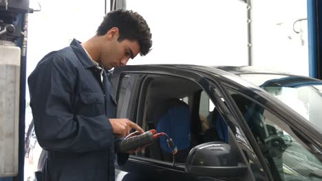 un guapo mecánico revisando un coche