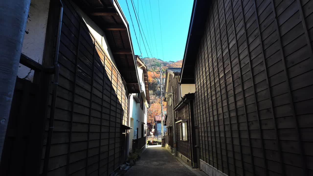 First person view walking along narrow side street in Narai juku post town, Japan, on sunny autumn morning