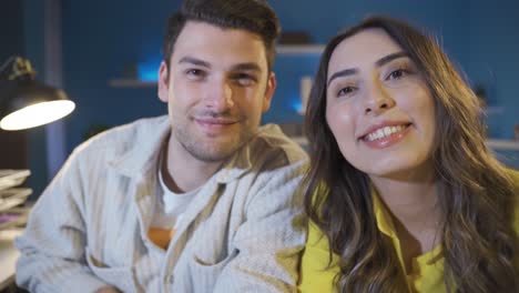 Happy-couple-at-home-smiling-and-waving-at-camera.