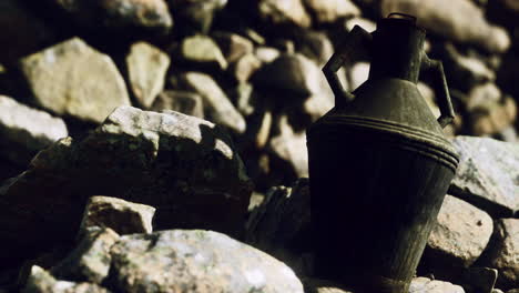 antique jug resting on rocky ground in a natural setting at dusk
