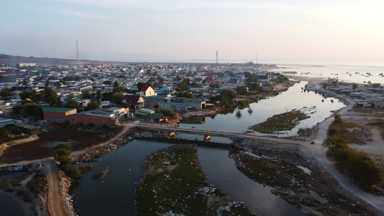 escena de la ciudad vietnamita con río contaminado al atardecer