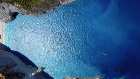 Aérea:-Vista-De-Arriba-Hacia-Abajo-De-La-Playa-Del-Naufragio-De-Navagio-En-Zakynthos,-Grecia-Durante-El-Verano