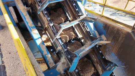 panning shot of a heavily used blades on a conveyor used for wood chips