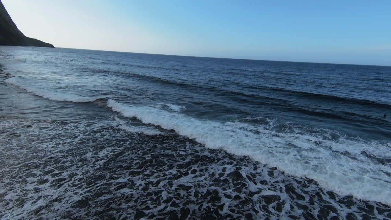 Fpv drone flight above river mouth of Hawaii Island towards Pacific Ocean with waves during beautiful day.