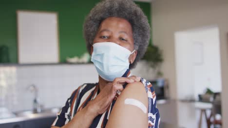 Happy-senior-african-american-senior-woman-showing-plaster-on-arm-after-covid-vaccination