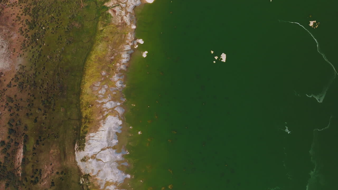 White salty pieces peeping out from Mono Lake, California, USA. Aquamarine water of saline lake from bird's eye view.