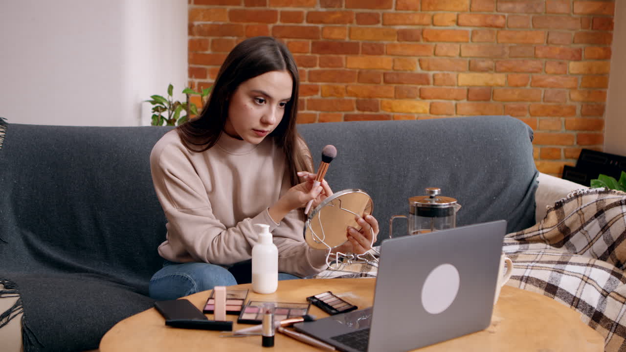 Woman Applying Makeup While Watching a Tutorial Video
