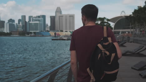 hombre caminando a lo largo de marina bay en singapur