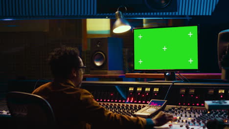 productor de música afroamericano trabajando con pantalla verde en la pc