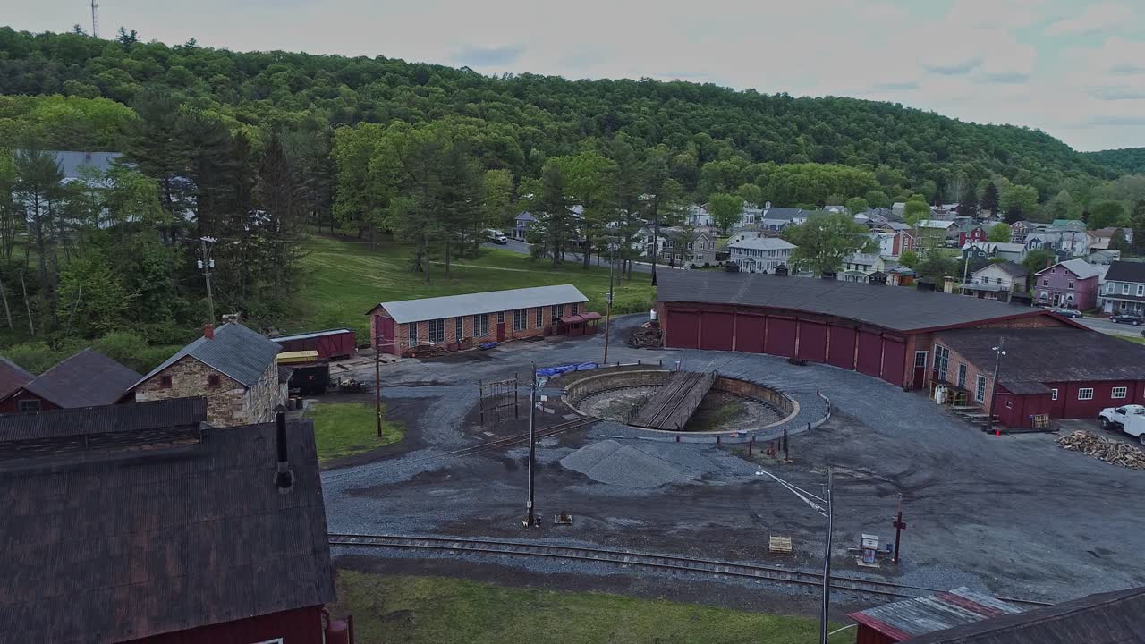 una vista aérea de una casa redonda de ferrocarril de carbón de vía estrecha abandonada y una plataforma giratoria que comienza a restaurarse