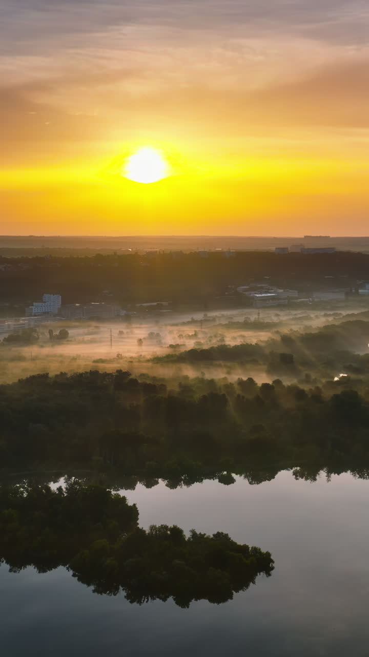 Aerial drone view of a lake surrounded by trees in Chisinau, Moldova at sunrise. Vertical