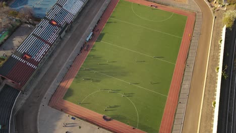 aerial top down view showing players having a hockey match at the stadium