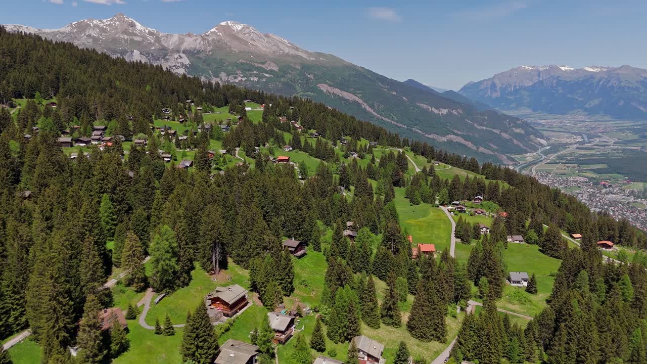Brambrüesch in switzerland with alpine homes and green mountain hills, aerial view