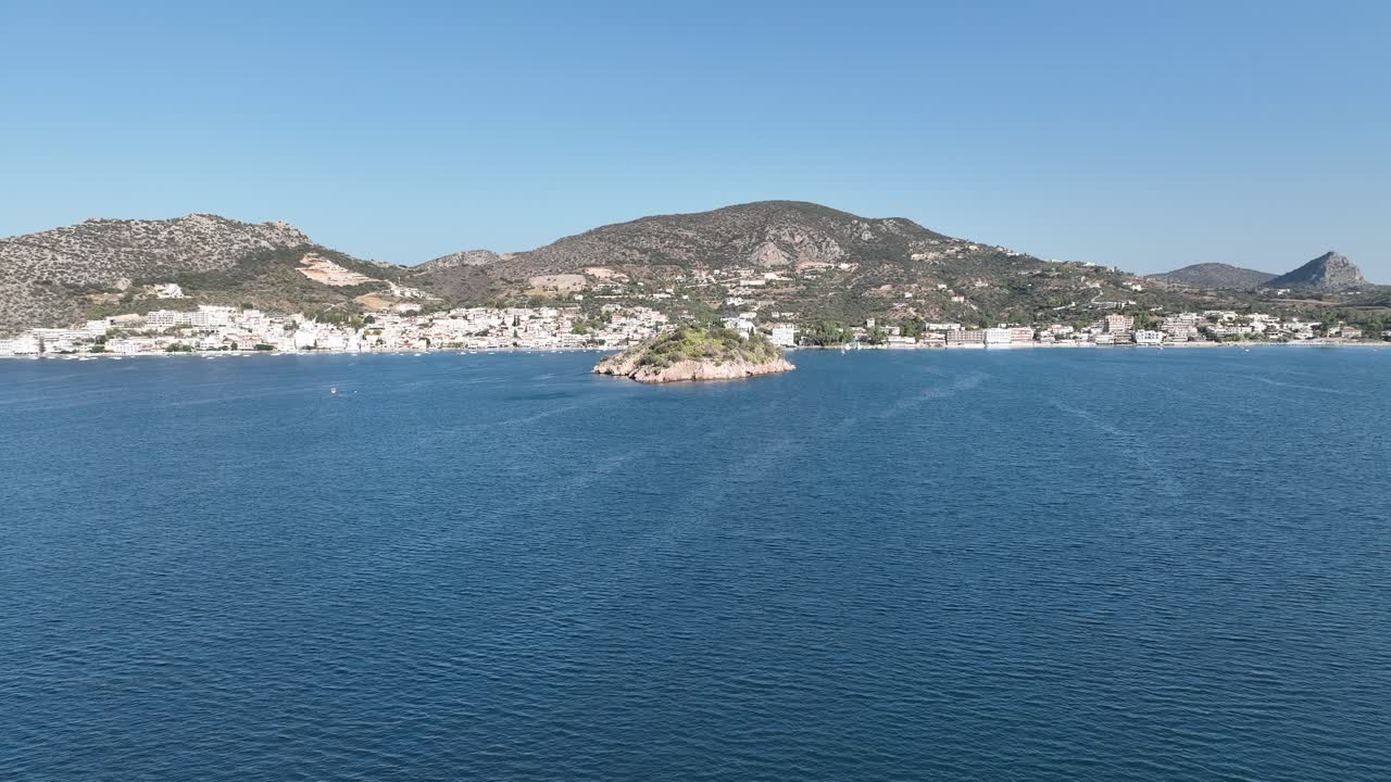 Drone flight over the sea and a small island near Tolo, Greece