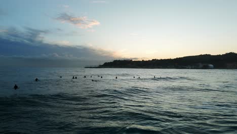 Grupo-De-Surfistas-Esperando-Olas-Al-Atardecer,-Varazze,-Liguria-En-Italia