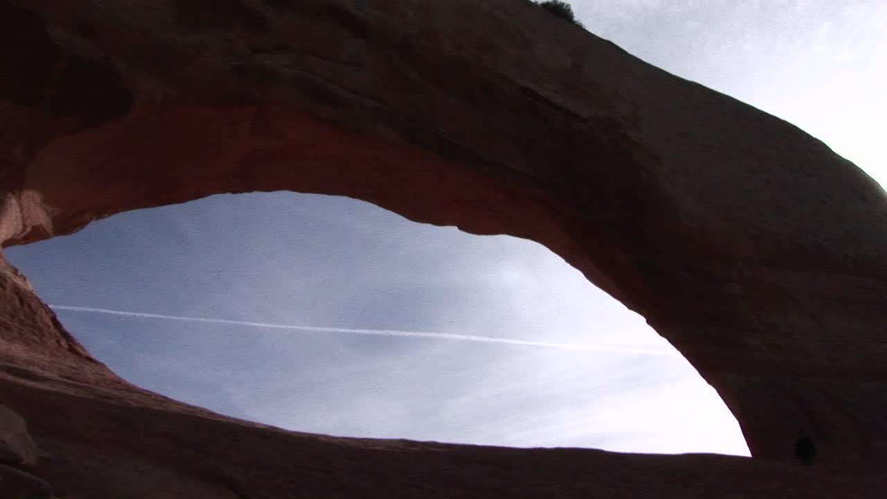 아치 국립공원 유타에 있는 거대한 사암 아치 아래를 걷는 사람