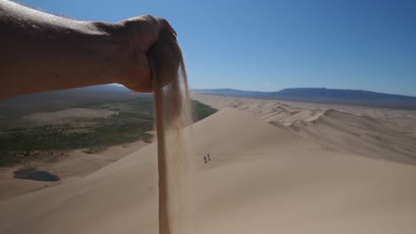 arena cayendo de la mano en cámara lenta desierto de gobi mongolia