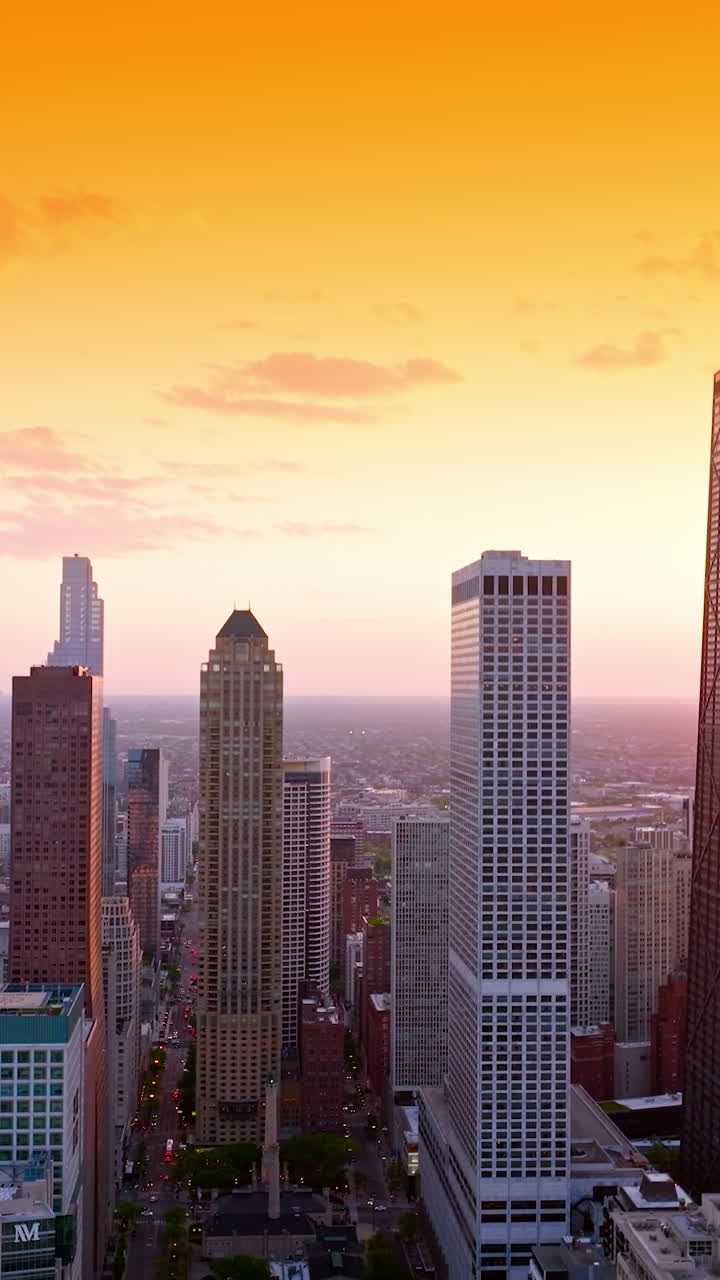 Fascinating scenery of the huge city at sundown. Terrific buildings and streets of Chicago, Illinois against orange sky backdrop. Vertical video