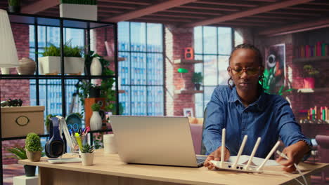 black woman at home examines the modem and troubleshooting guide book