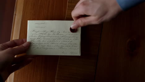 hands exchanging a sealed envelope